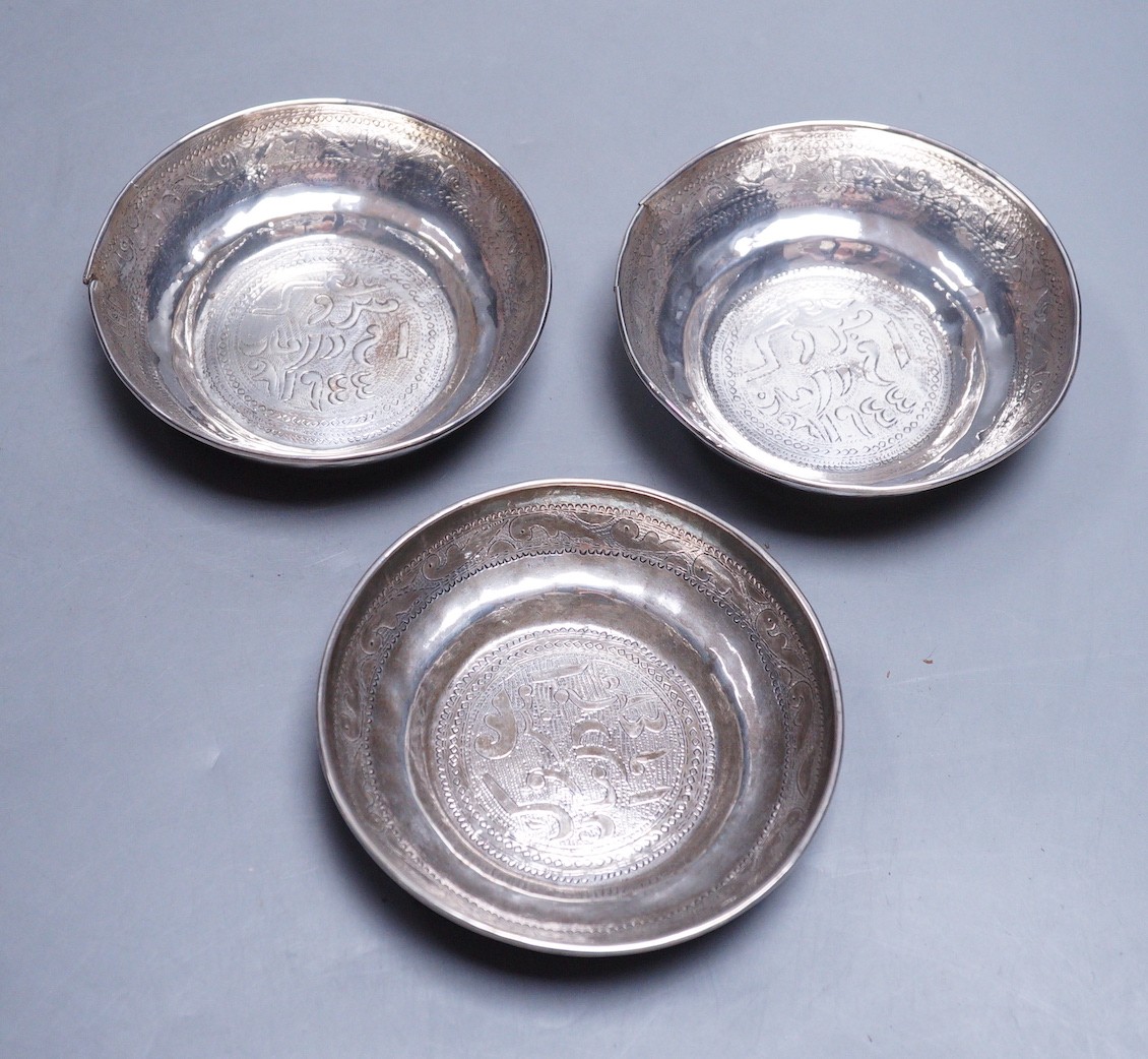 Three Persian engraved white metal finger bowls, (a.f.) diameter 10.6cm, 235 grams.